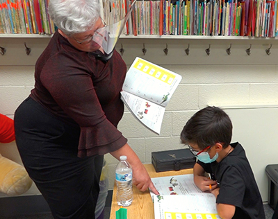 teacher pointing at book