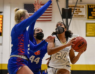 girl going up for shot against two defenders