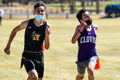 two boys running in masks