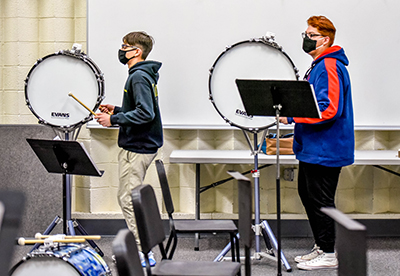 two students hitting drums