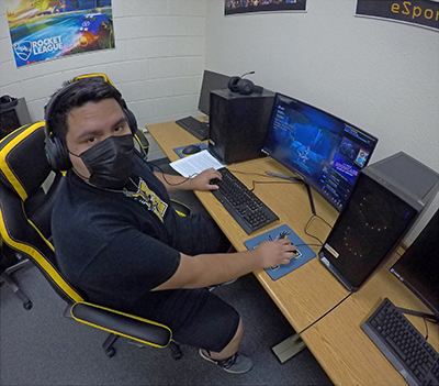 student in front of computer with mask on