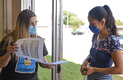 teacher in mask talking to student in mask