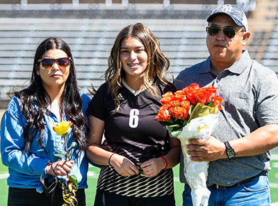 girl player with smiling parents and flowers