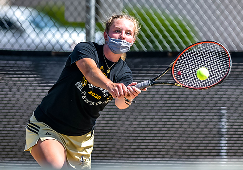 girl hitting tennis ball