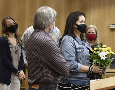 woman with flowers while others smile