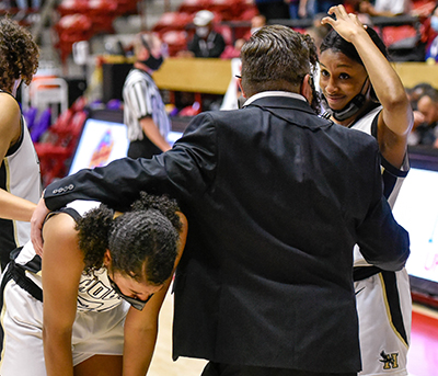 coach consoling two players