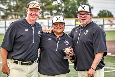 three guys standing together holding a ball