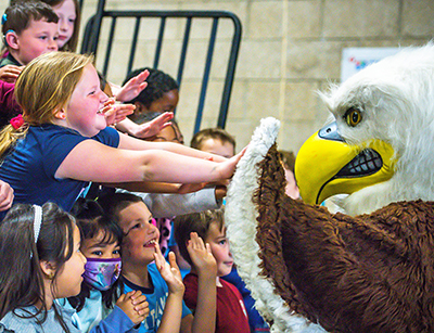 girl high fiving eagle mascot