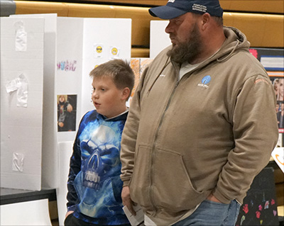 dad and student looking at display