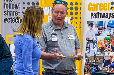 man talking to woman in front of display