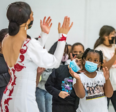 kid clapping while watching woman dance