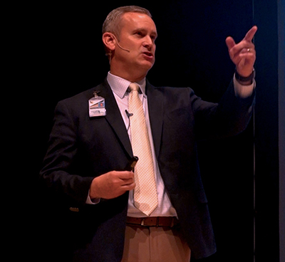 man on stage pointing