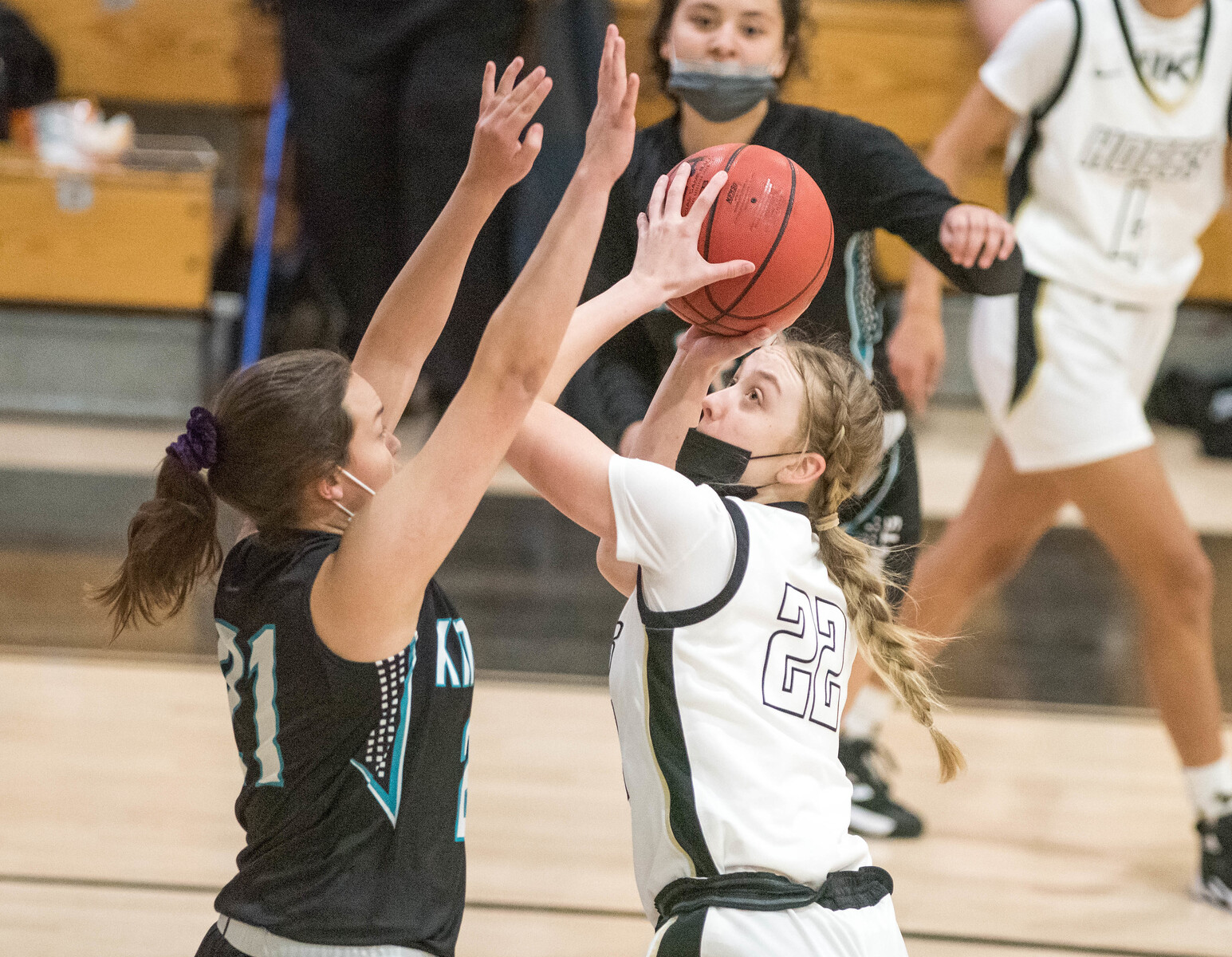 girl trying to shoot ball while being blocked