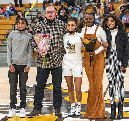 player standing with her family at half court