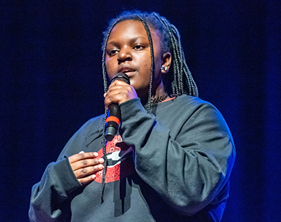 girl on stage singing into microphone