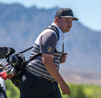 boy walking with golf bag on shoulder