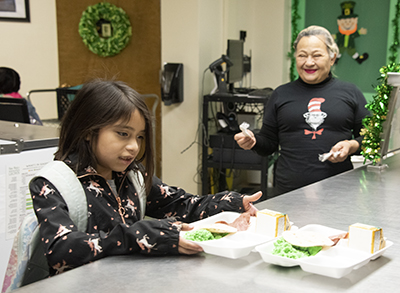 girl receiving tray with green eggs