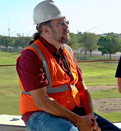 man sitting in hard hat and vest