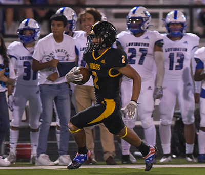 football player with ball running up sideline