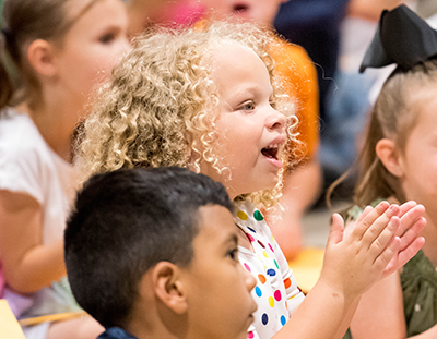 blonde girl sitting on floor clapping