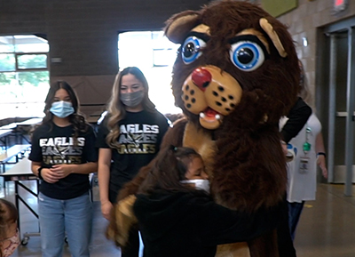 person in bear costume hugging kid