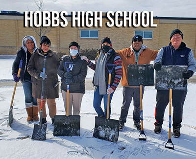 people standing in snow with shovels