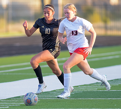 two girls fighting for ball down sidelines