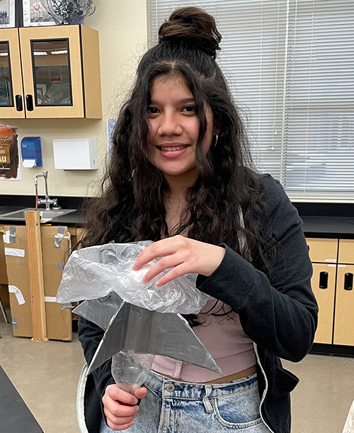 girl holding homemade rocket