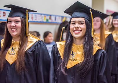 two smiling girls in caps and gowns