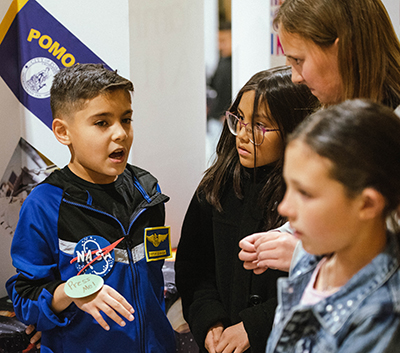 student in astronaut uniform speaking