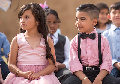 dressed up boy and girl sitting next to each other