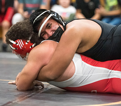 wrestler laying on top of another wrestler