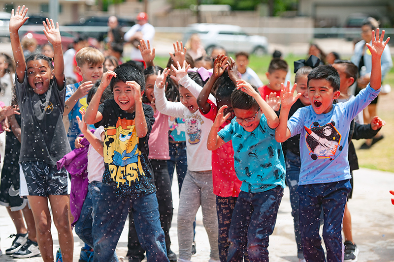 laughing kids getting squirt by water