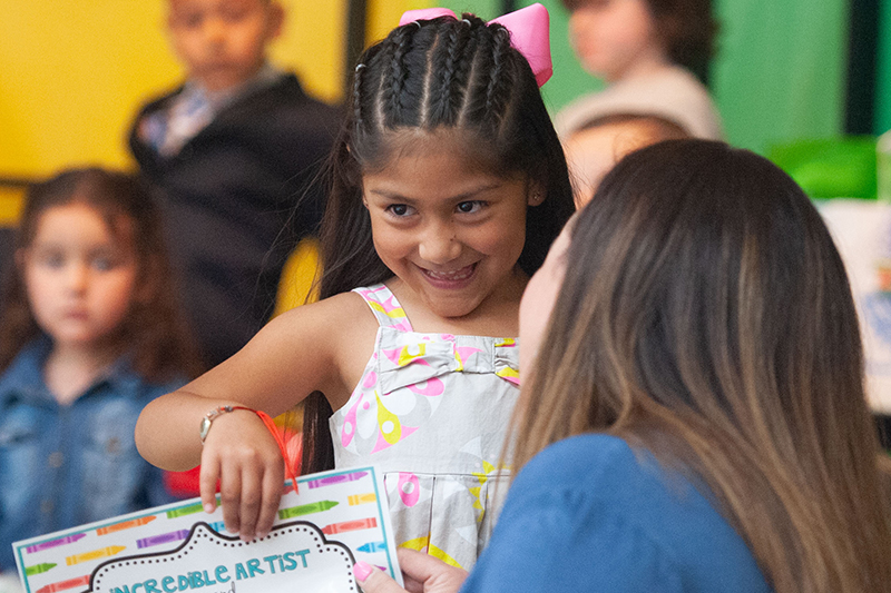 girl smiling while getting certificate