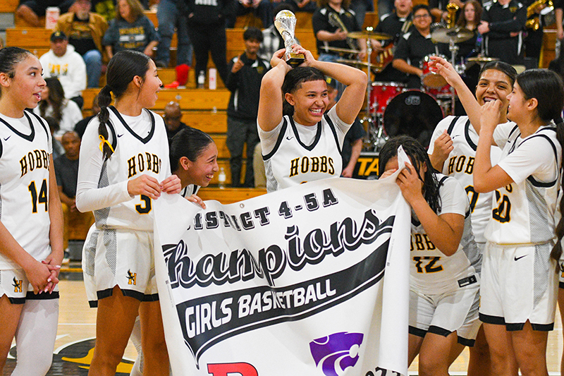 team celebration with girl lifting trophy