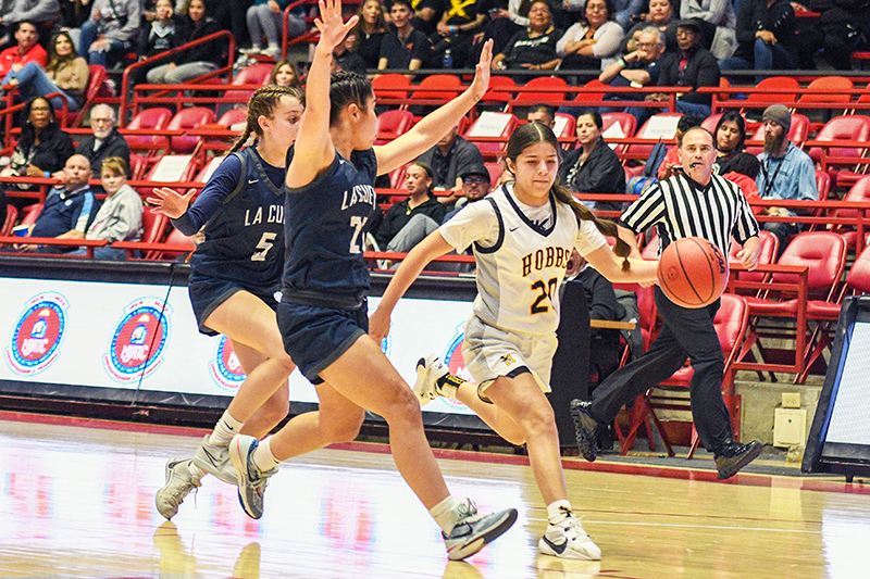 Hobbs player driving with two defenders