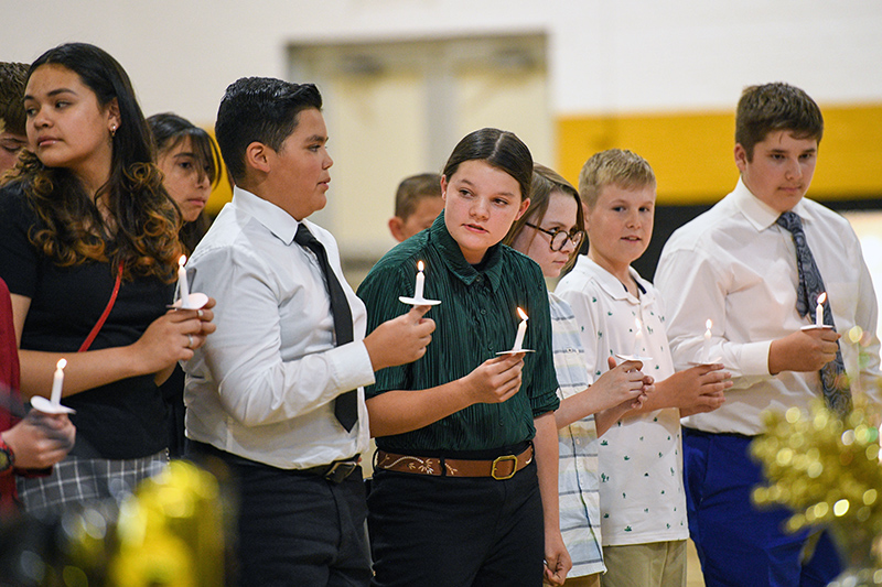 students holding candles at ceremony