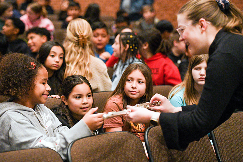 musician showing instrument to students