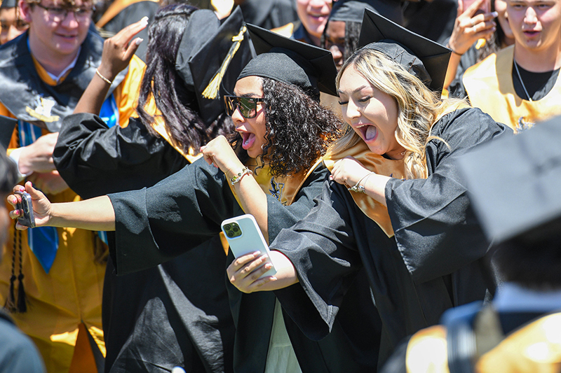 two smiling girls in cap and gown