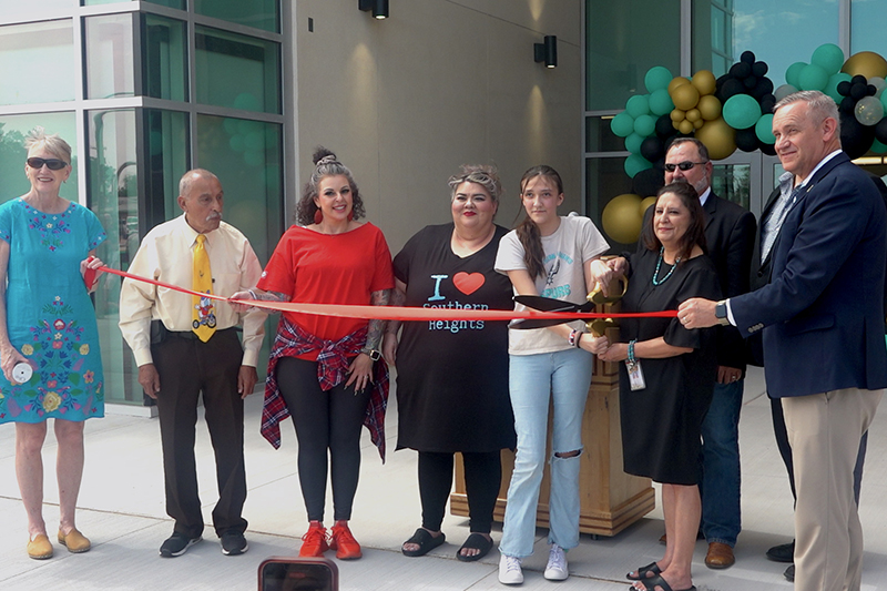 group of people standing in front of ribbon