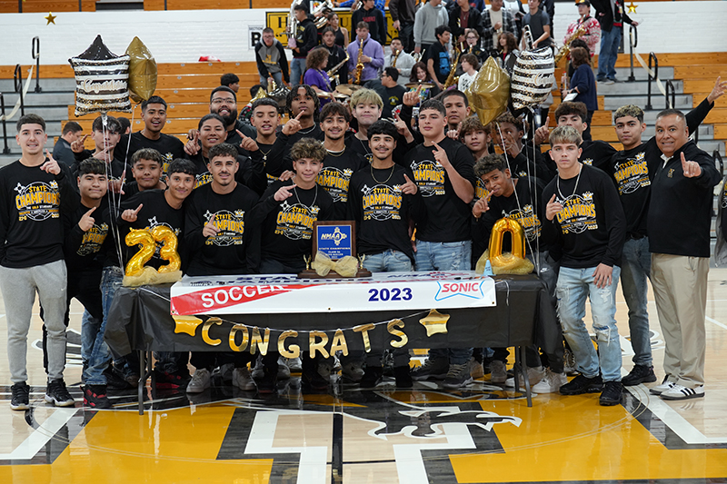 group of players in front of trophy