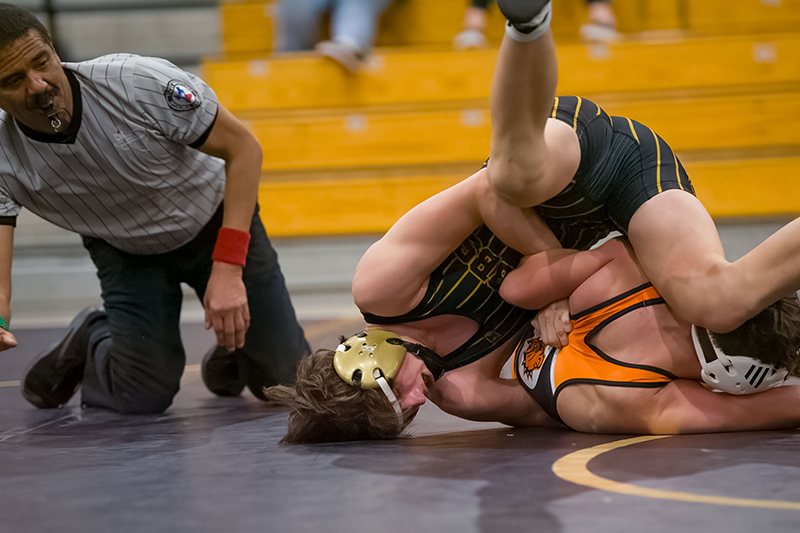 two wrestlers with ref in background