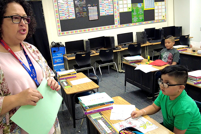 teacher at front of class in front of student