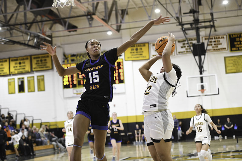 player at basket with defender