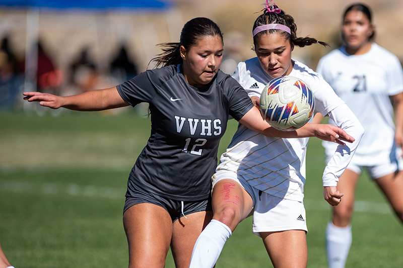 girl soccer players fighting for ball