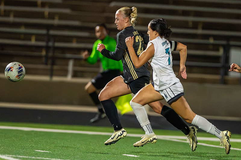 girl running down soccer ball