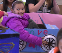 girl sitting in cardboard box car