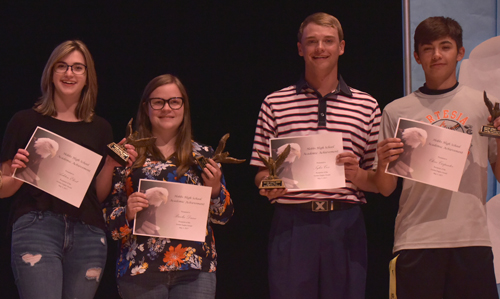 students holding up scholarships