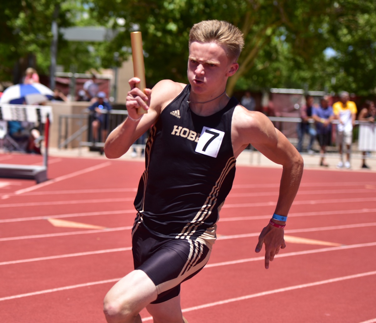 student running relay with baton in hand